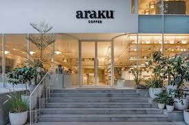 "Araku Coffee café entrance with modern glass architecture, lush greenery, and a welcoming ambiance, making it one of the Best Cafés in India for specialty coffee lovers."